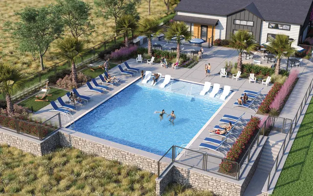 A modern swimming pool area with lounge chairs and palm trees, surrounded by landscaped gardens and a club house in an outdoor setting.