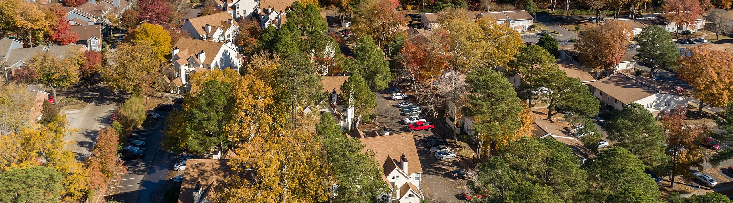 Breathtaking aerial view of a charming neighborhood nestled in lush autumn foliage, offering a serene and picturesque living environment.