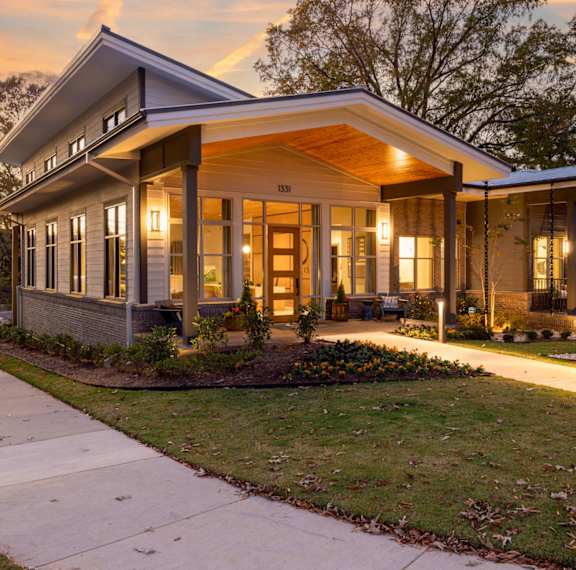 A modern house with a front porch and a walkway leading to the front door.