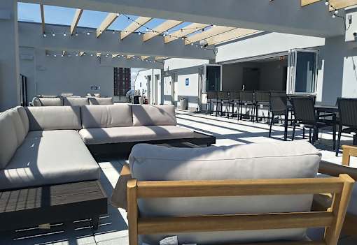 A patio with a white couch and a wooden chair.