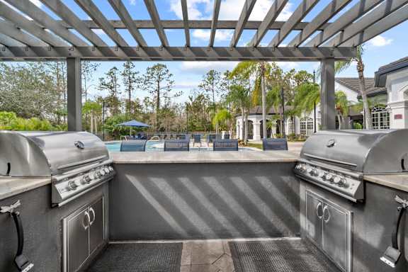pergola with two grills overlooking pool at The Grand Reserve at Tampa Palms Apartments, Florida, 33647