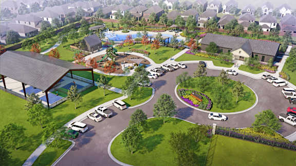 A bird's eye view of a residential area with a roundabout and houses.