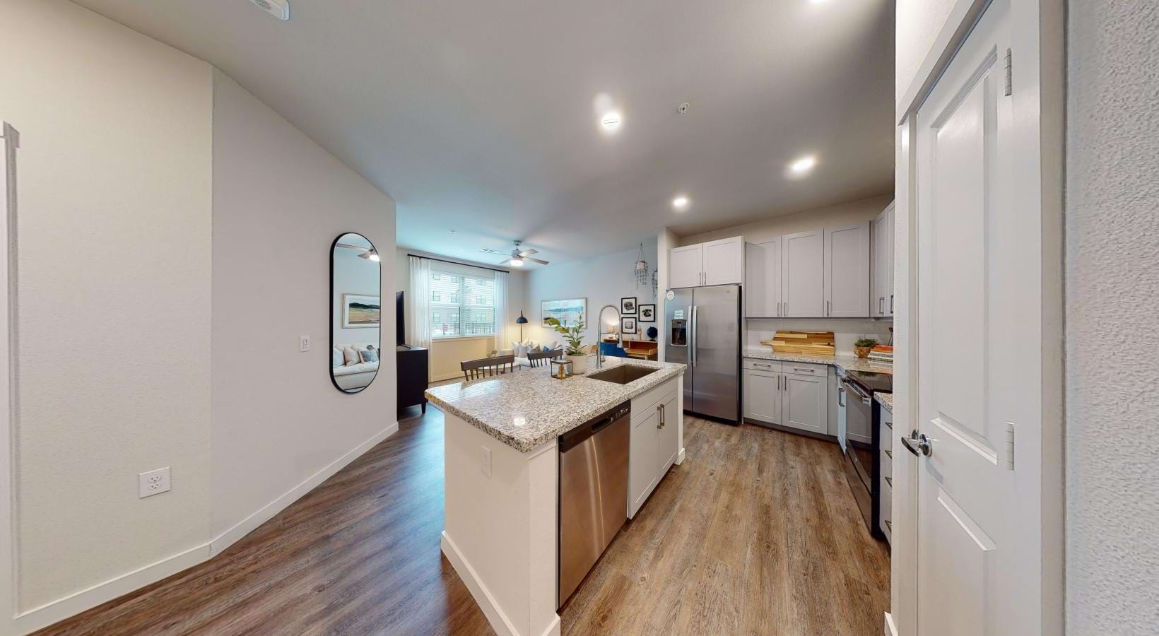 an entry into a kitchen with white cabinets