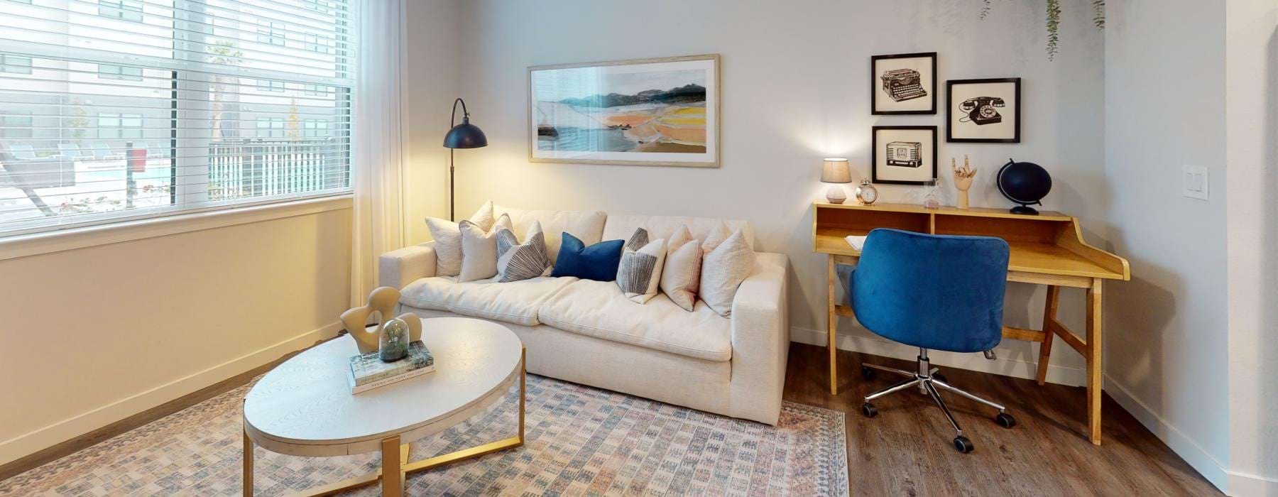 a living room with a couch and a table and windows