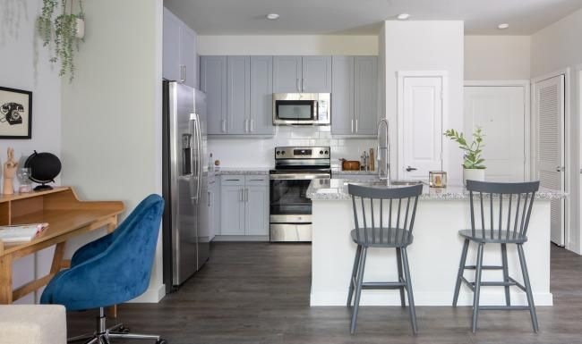 a kitchen with a bar table and chairs