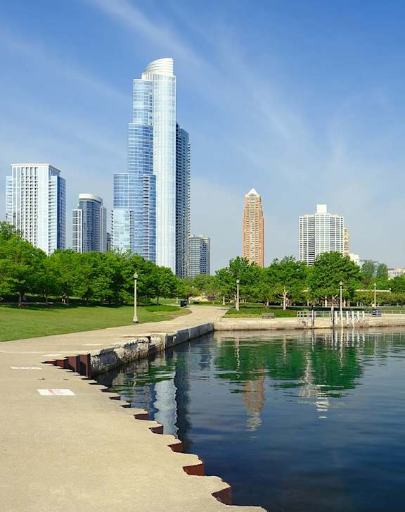 A city skyline is reflected in the water.