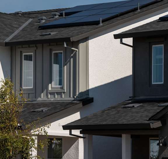 a row of houses with solar panels on their roofs