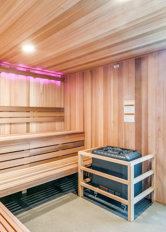 A sauna room with wooden benches and a heater.
