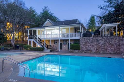 A house with a pool in front of it.