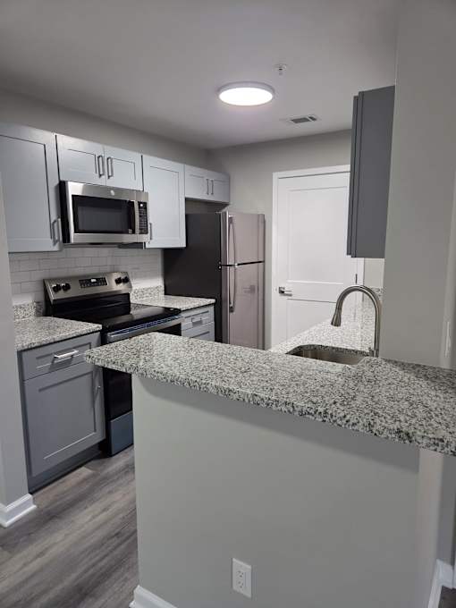 A kitchen with granite countertops and stainless steel appliances.