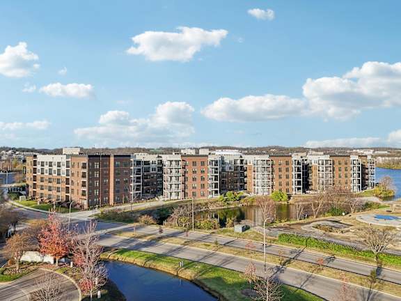 A large apartment complex sits next to a river.