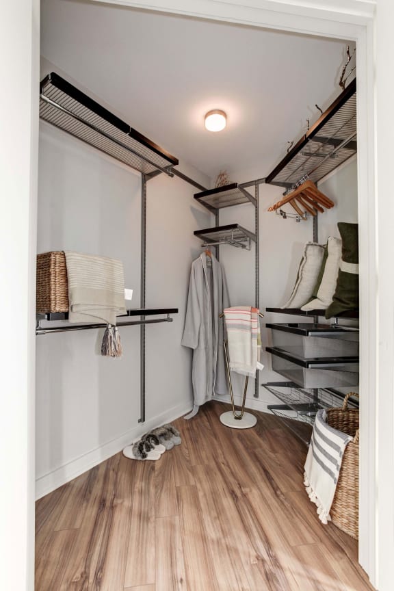 a walk in closet with a metal shelving system and a white chair