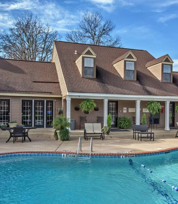 Resort-style pool with lounge chairs and green landscaping near a clubhouse at Stevens Creek Commons in Augusta, Georgia