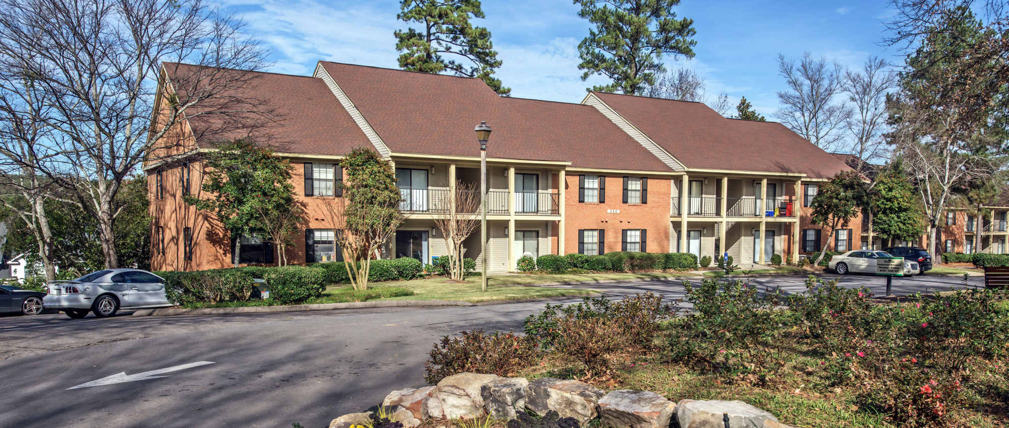 Apartment community with landscaped gardens, parking area, and balconies on multiple units at Stevens Creek Commons in Augusta, Georgia