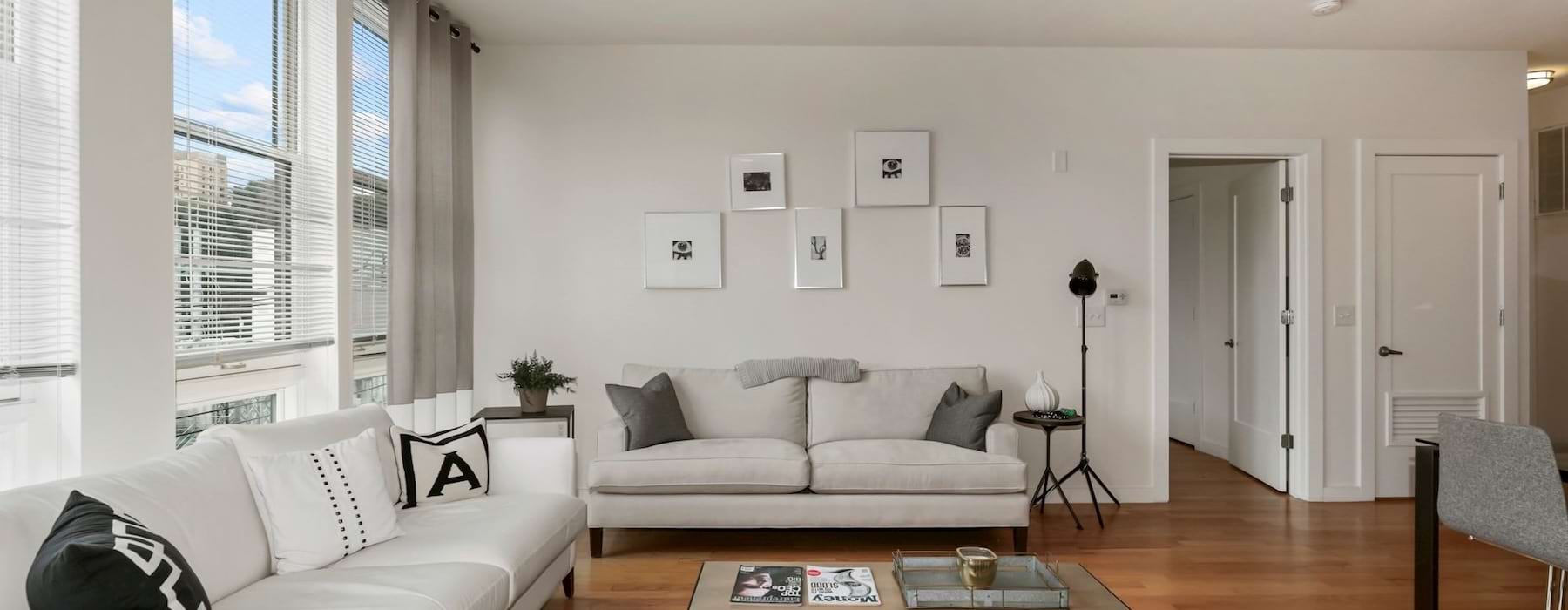 a living room with a large window and couches