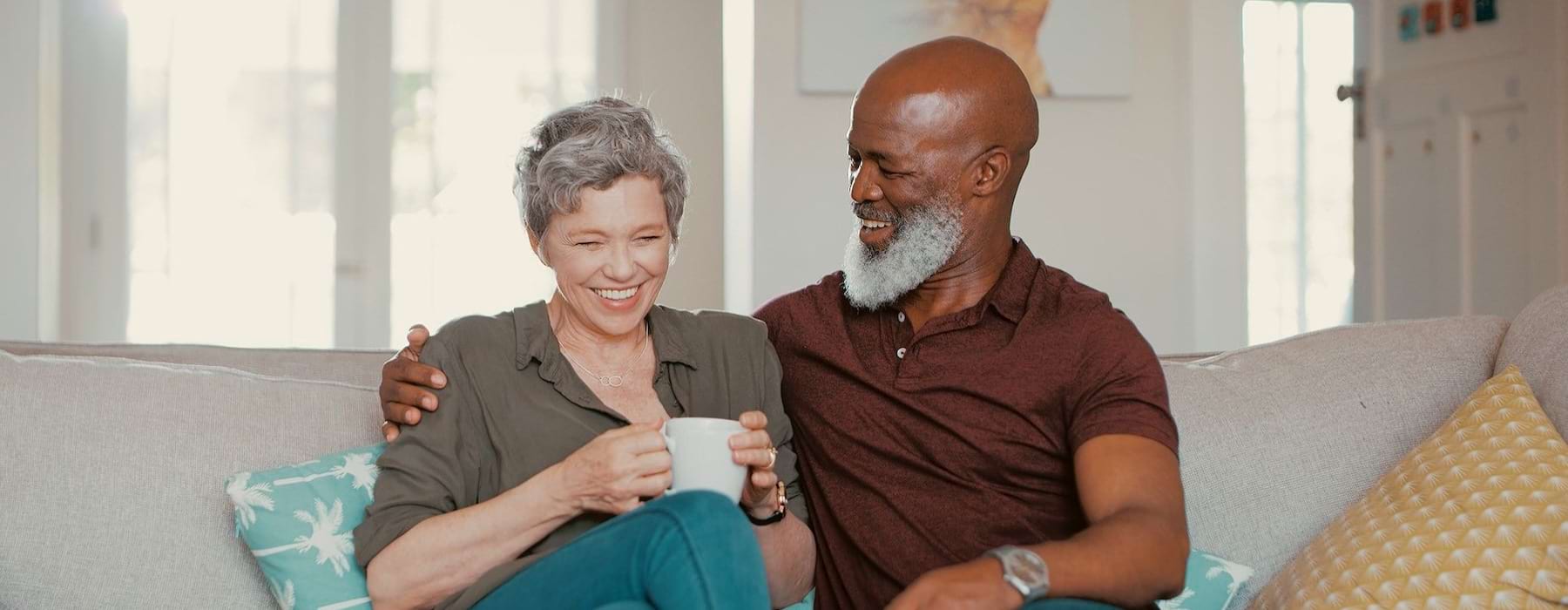 smiling, older couple, sit together on a couch