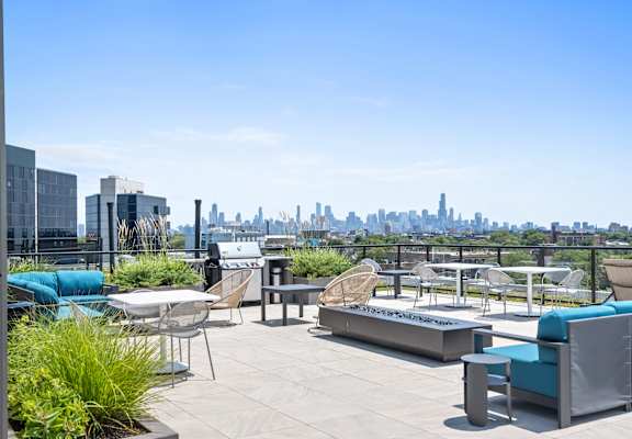 A rooftop patio with a view of the city skyline.