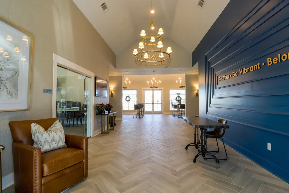 Elegant communal space featuring soft lighting, leather seating, and stylish decor with a vibrant blue accent wall, perfect for social gatherings.