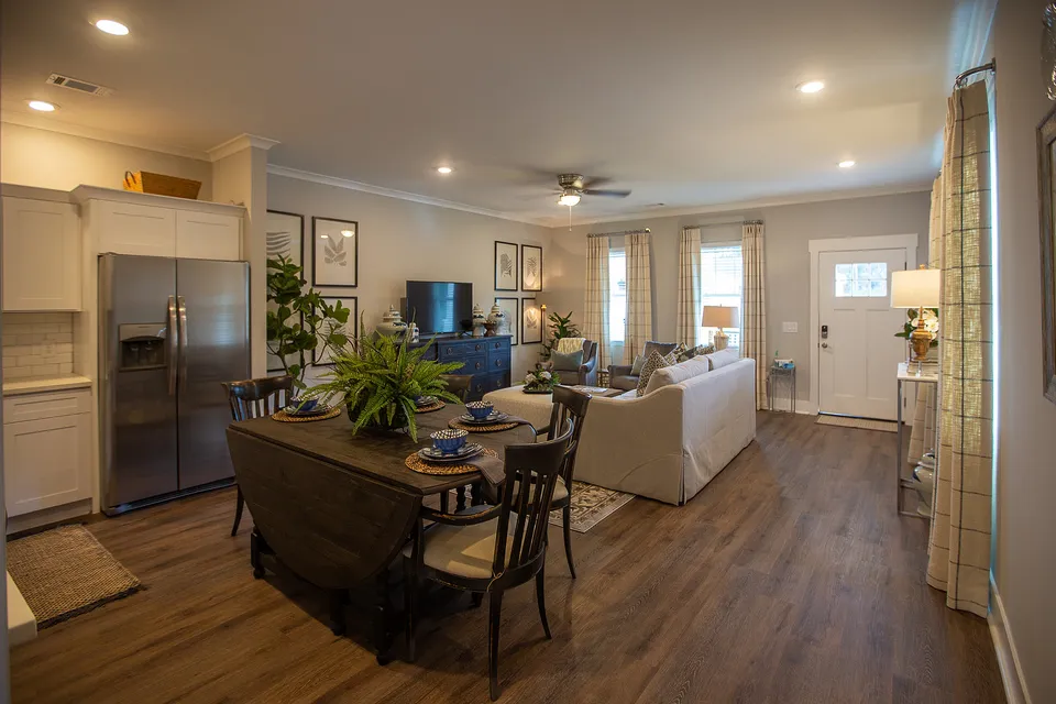 Inviting open-concept living room and kitchen with elegant decor, cozy seating, and abundant natural light.