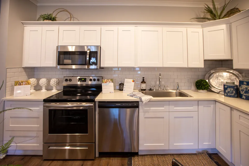 Modern kitchen with sleek stainless steel appliances, elegant white cabinetry, and stylish backsplash.