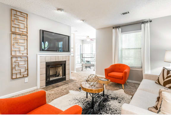 A living room with a fireplace, a television, and a chair.