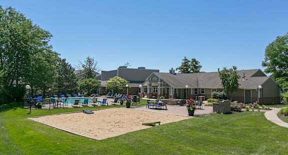 Cornhole court, swimming pool, and resident clubhouse house patio with firepit and barbecue stations