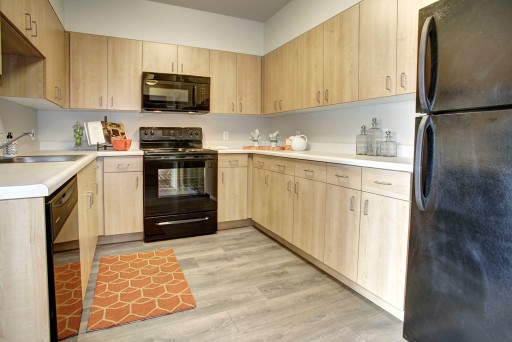 Hodge on 7th kitchen with new light wood cabinets and black applicances