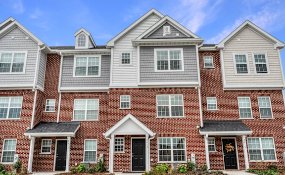 A row of houses with brick and grey exteriors.