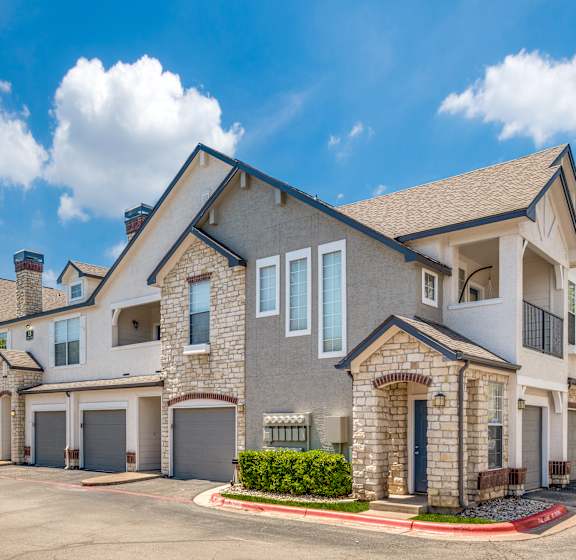 external view of a house with a driveway and garage doors