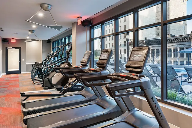 Modern apartment gym with state-of-the-art treadmills and vibrant city views.