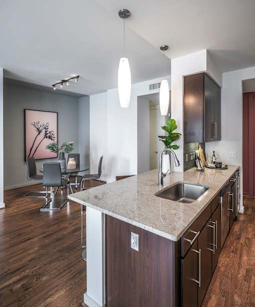 A kitchen with a marble countertop and wooden floors.