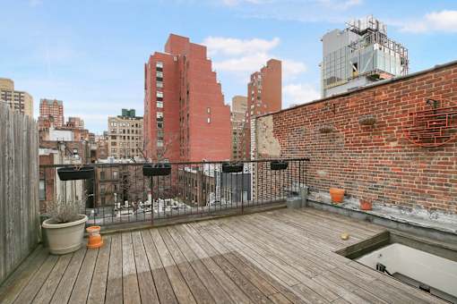 A wooden deck with a red building in the background.