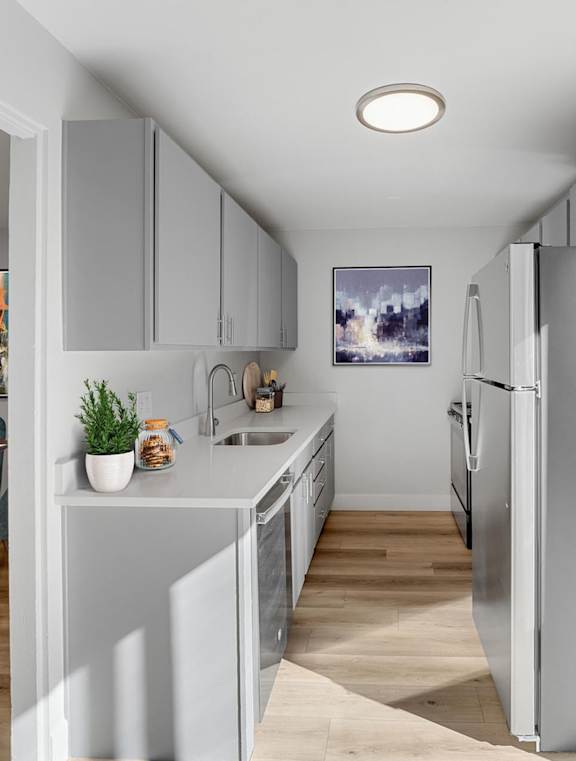 A modern kitchen with a dining table and chairs. at The Lex At Lowry, Denver, 80224