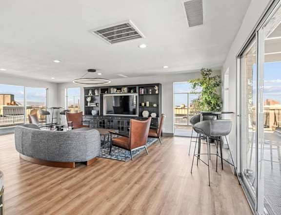 A modern living room with a large grey sofa and a television. at The Lex At Lowry, Denver, Colorado