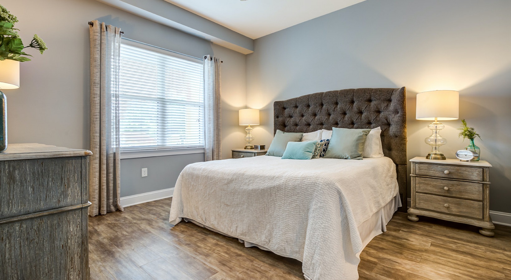 Open bedroom with rustic decor and warm lighting from lamps