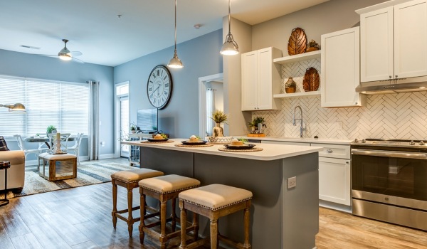 will lit kitchen with island and tall cabinets
