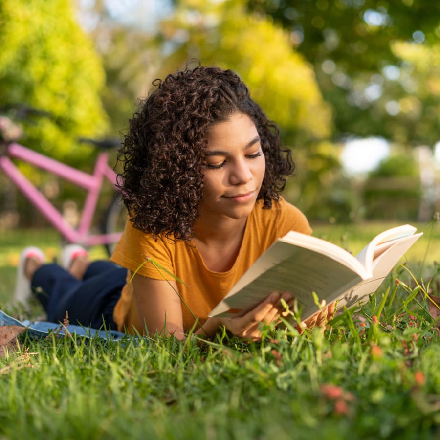 Resident reading in the grass of The Adair in Charlotte, North Carolina
