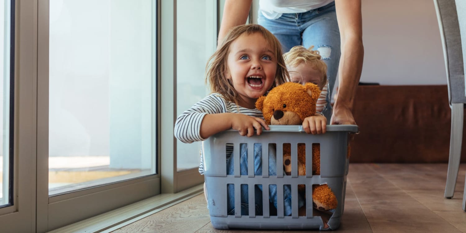 Resident playing with her daughter in a laundry basket at The Adair in Charlotte, North Carolina