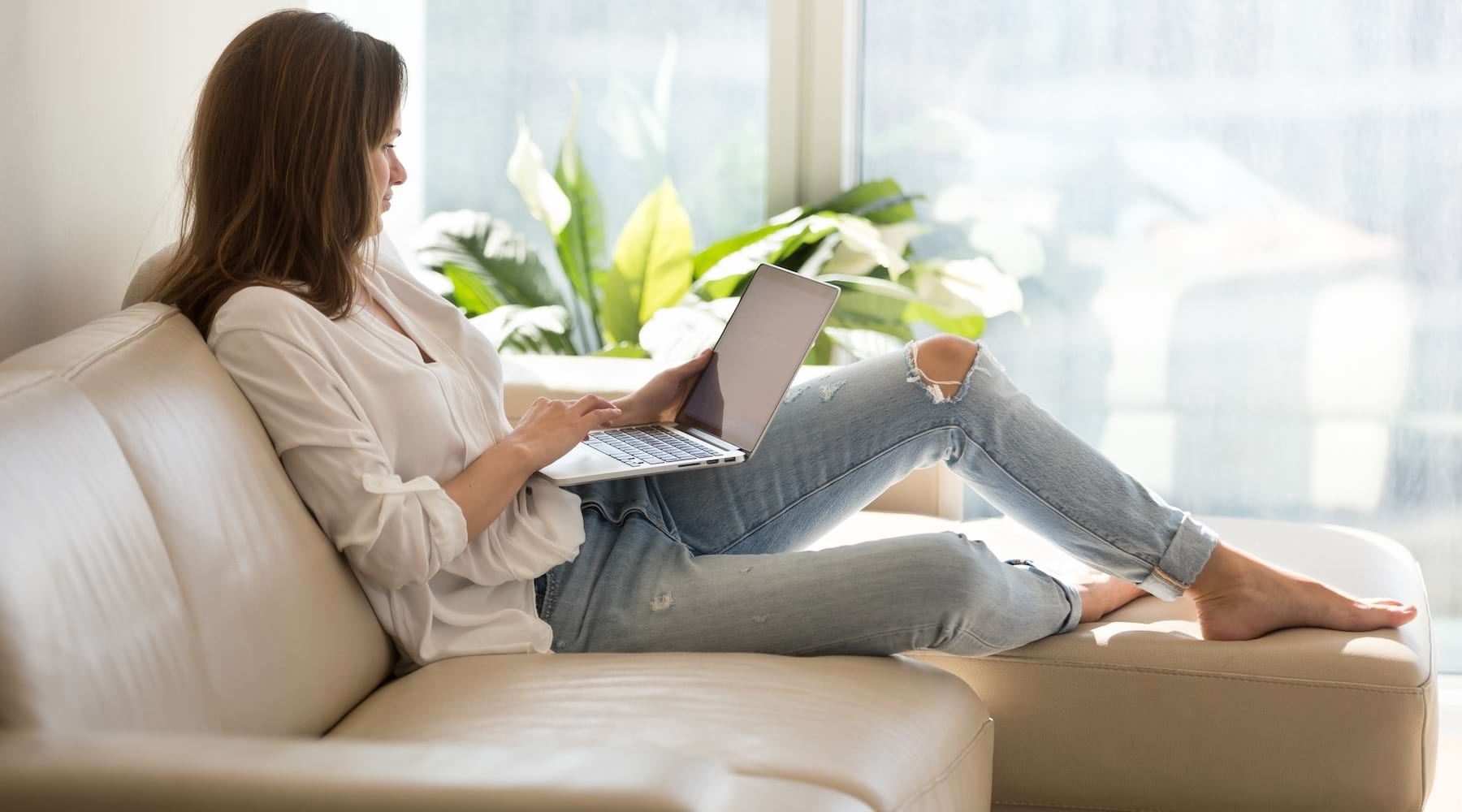 a woman sitting on a couch with a laptop