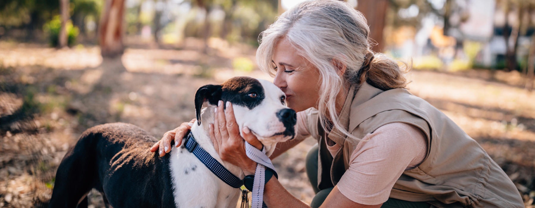Woman petting her dog in a local park