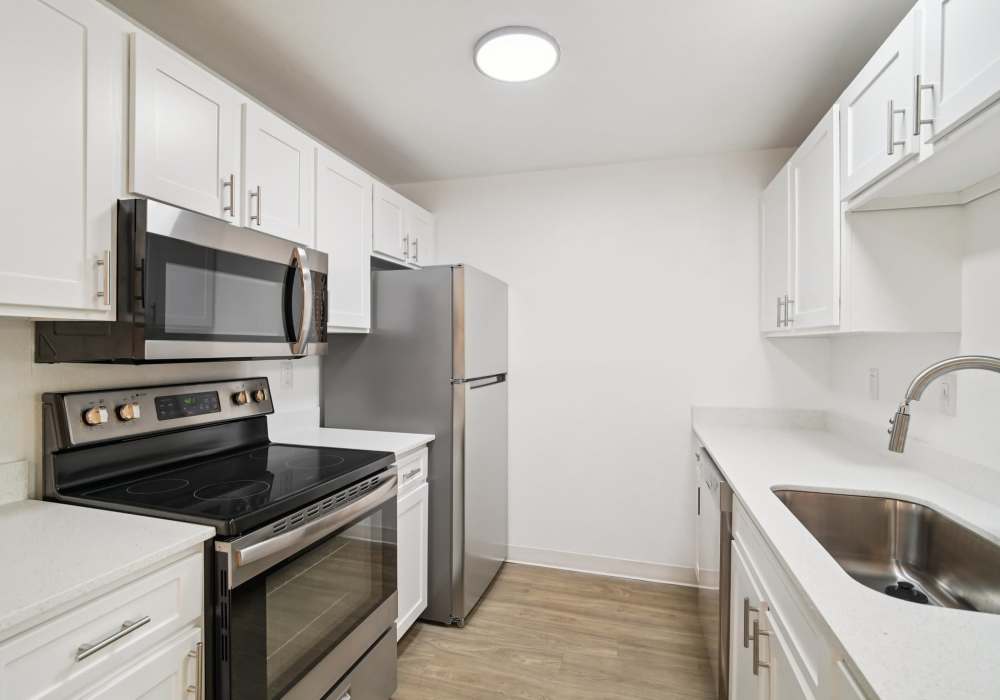 Kitchen with white cabinets and stainless steel appliances at Foundry on Fifth in Renton, Washington