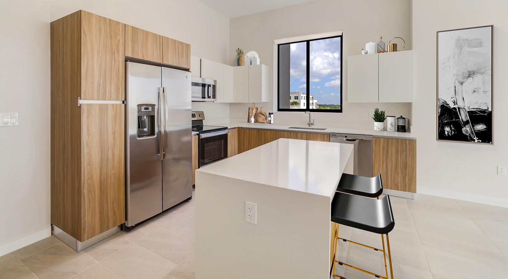 Spacious and well lit kitchen with wood floors and stainless steel appliances. 