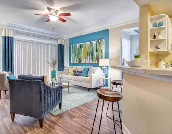 A living room with a blue chair and a white couch.