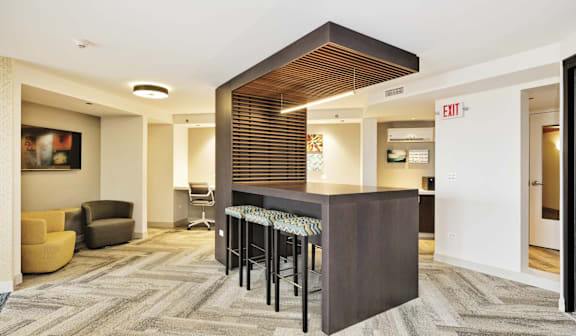 A room with a bar and chairs.