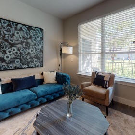 a living room with a blue couch and windows