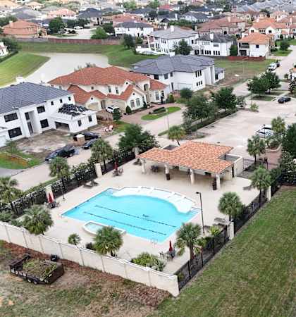A residential area with a tennis court and a swimming pool.
