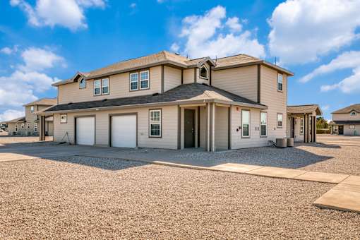 A large house with a gravel driveway in front of it.