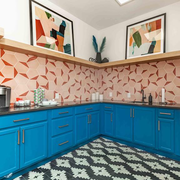 A kitchen with blue cabinets and a black and white checkered floor.