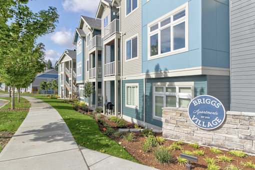 A row of townhouses with a sign that says Briggs Apartments Village.