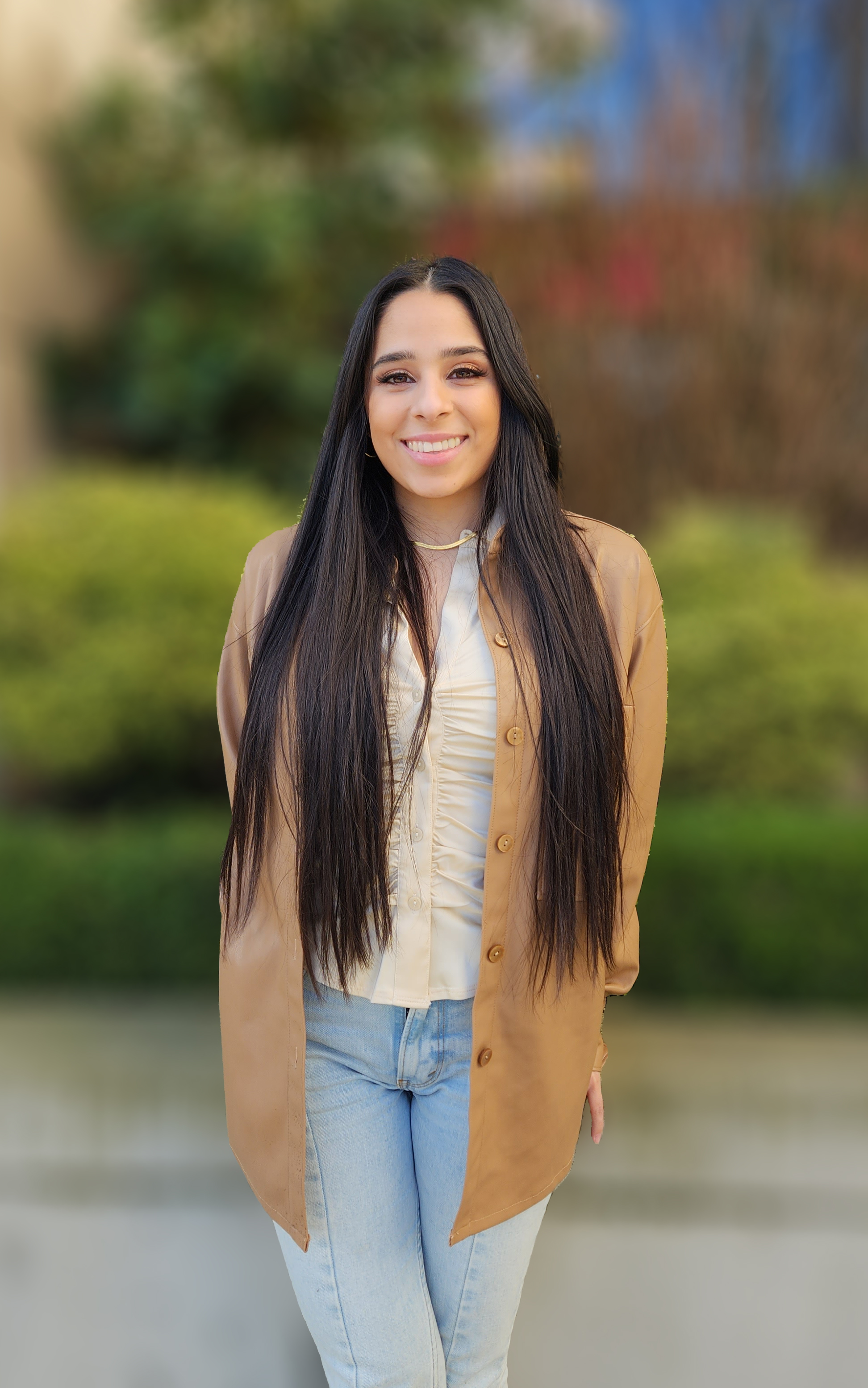 Headshot of Melissa Barajas, Assistant Community Manager, standing in front of bushes